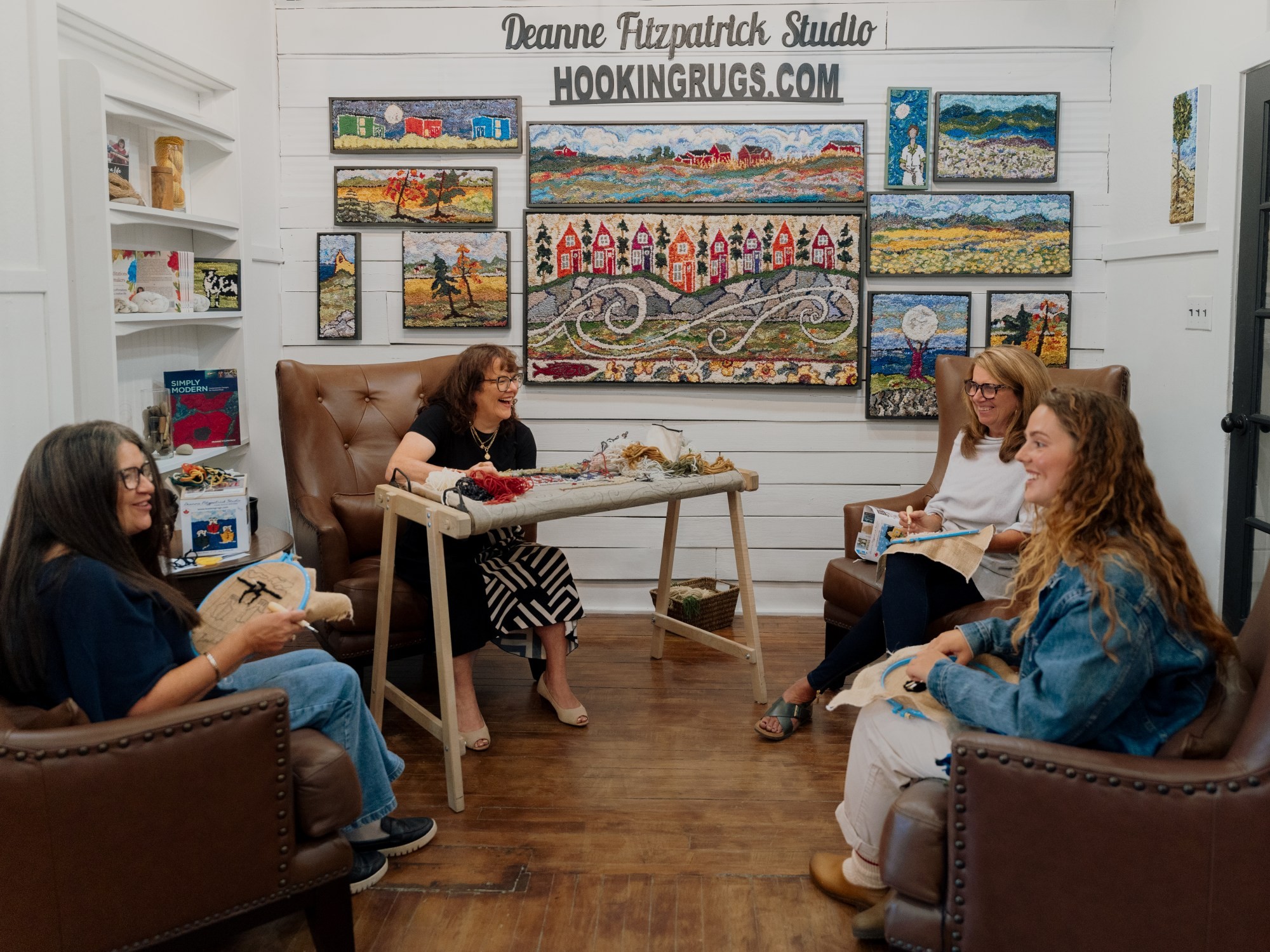 A group of women rug hooking with artist Deanne Fitzpatrick