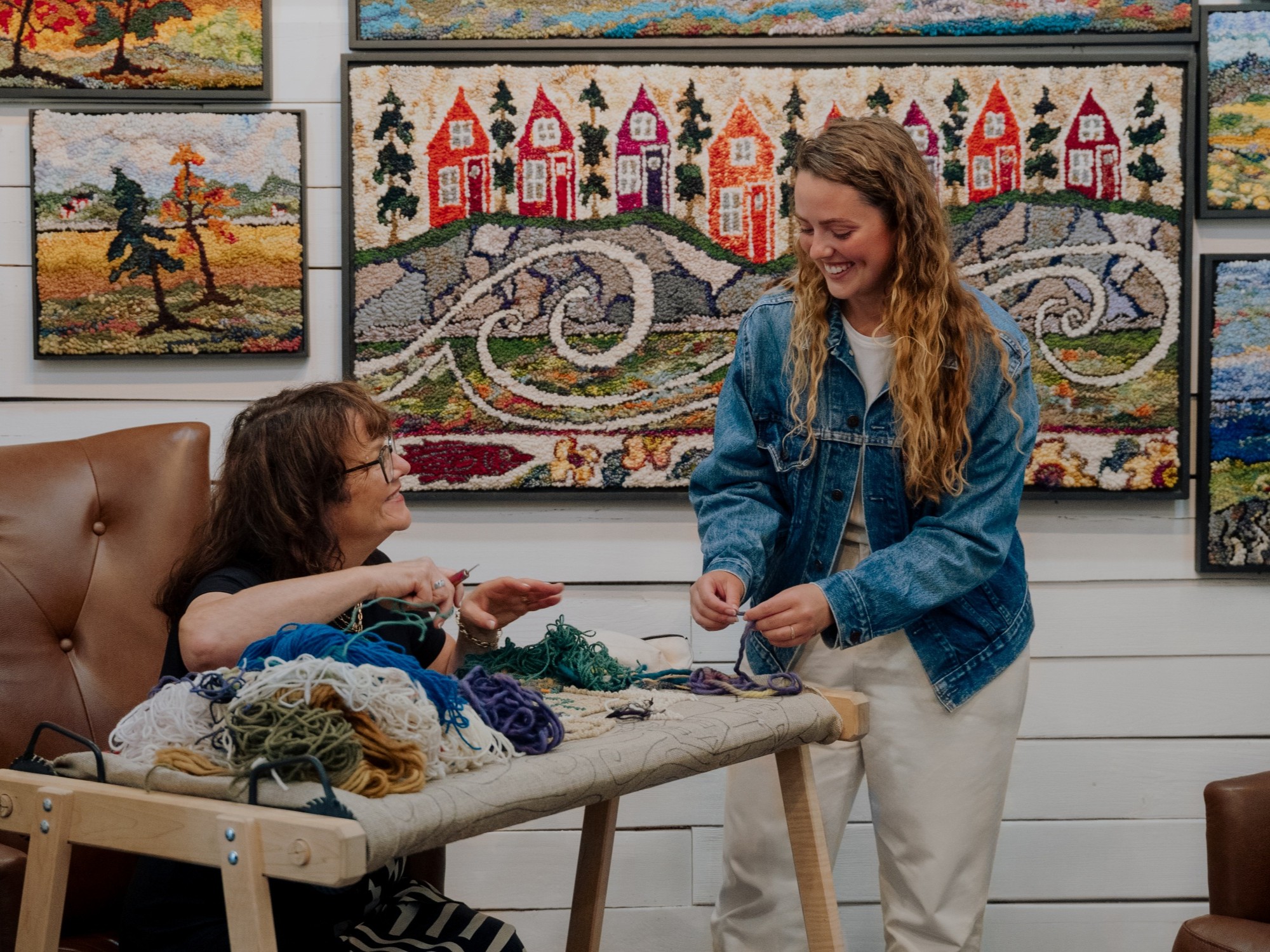 Artist Deanne Fitzpatrick engaging with a visitor while working at her studio