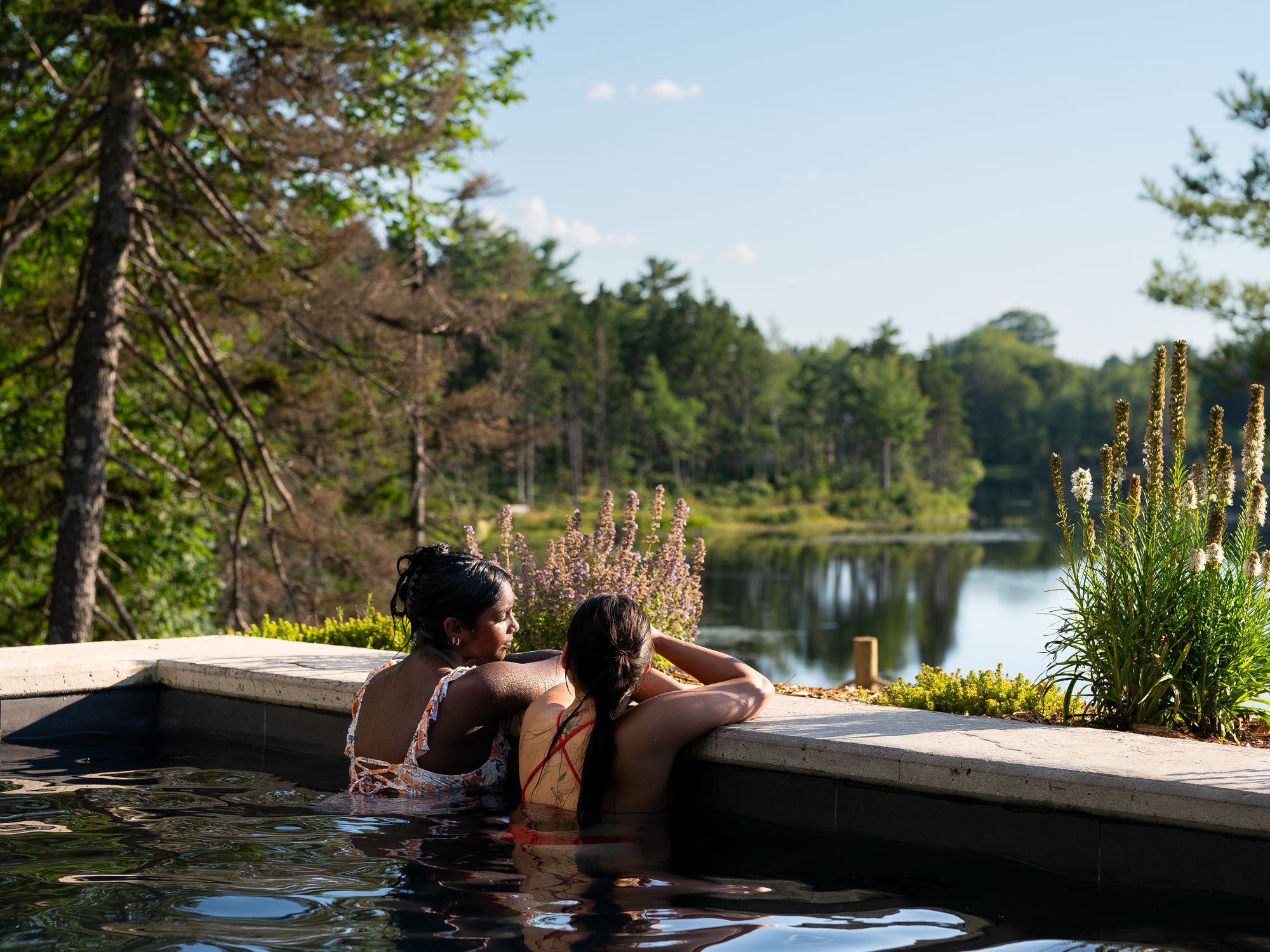 Two women in a warm pool at Sensea Spa looking out over a lake