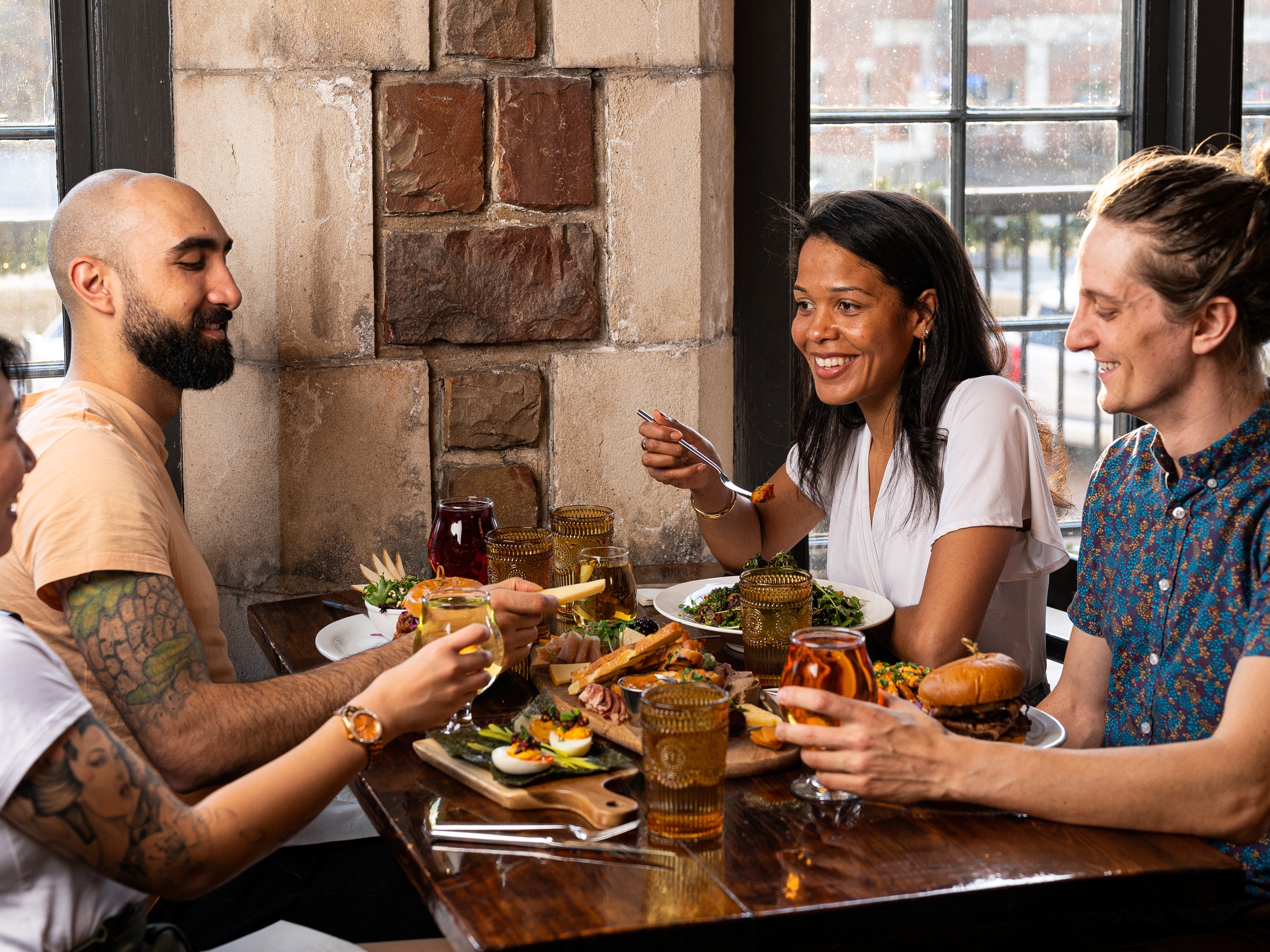 People sitting at a table enjoying food and drinks