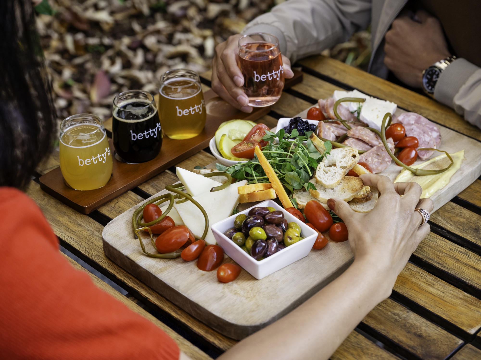 An over the shoulder view of a person taking food from a charcuterie board at Kitch'inn in Mahone Bay, Nova Scotia