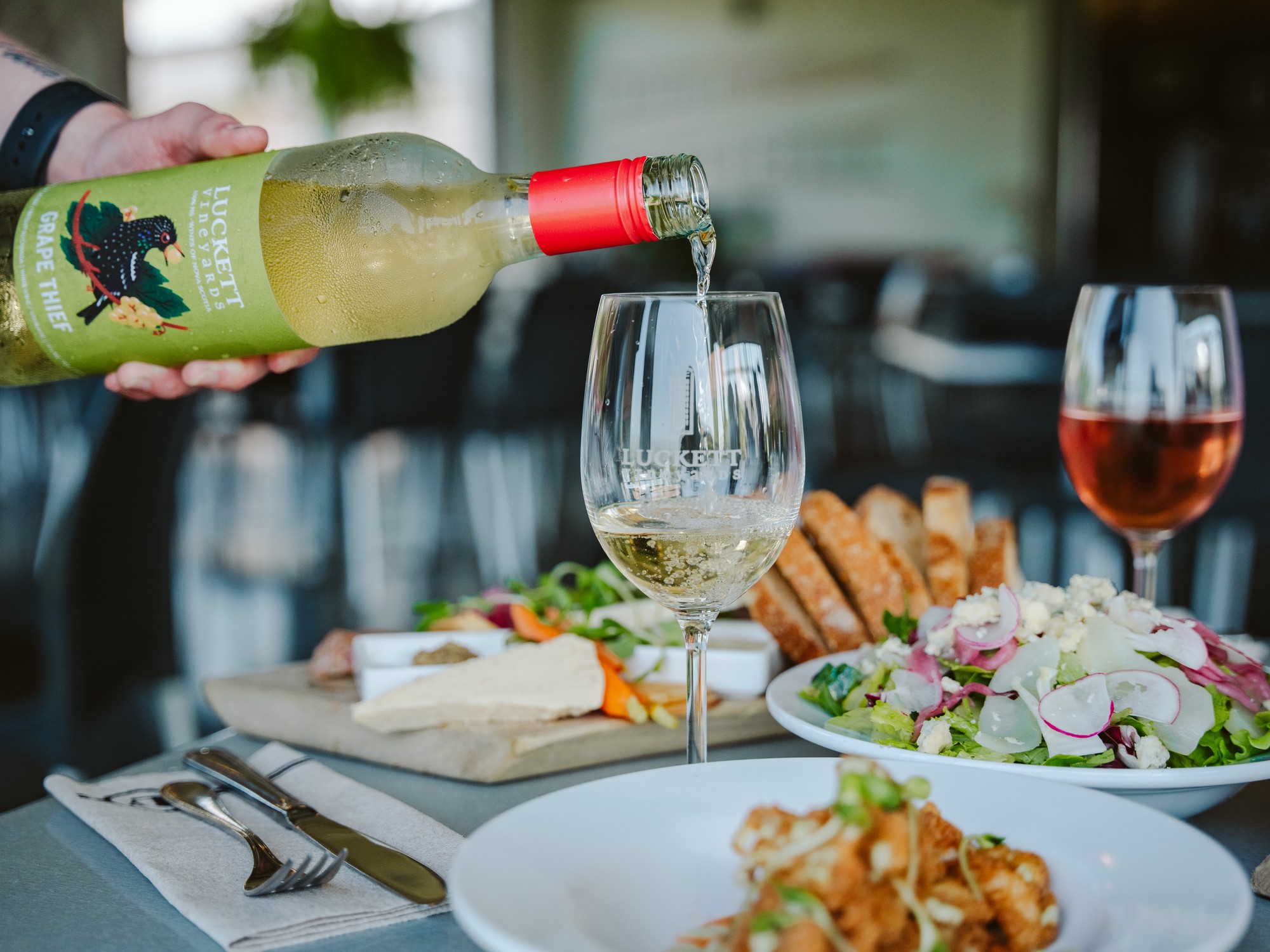 Wine is being poured into a glass at Luckett Vineyards in Nova Scotia