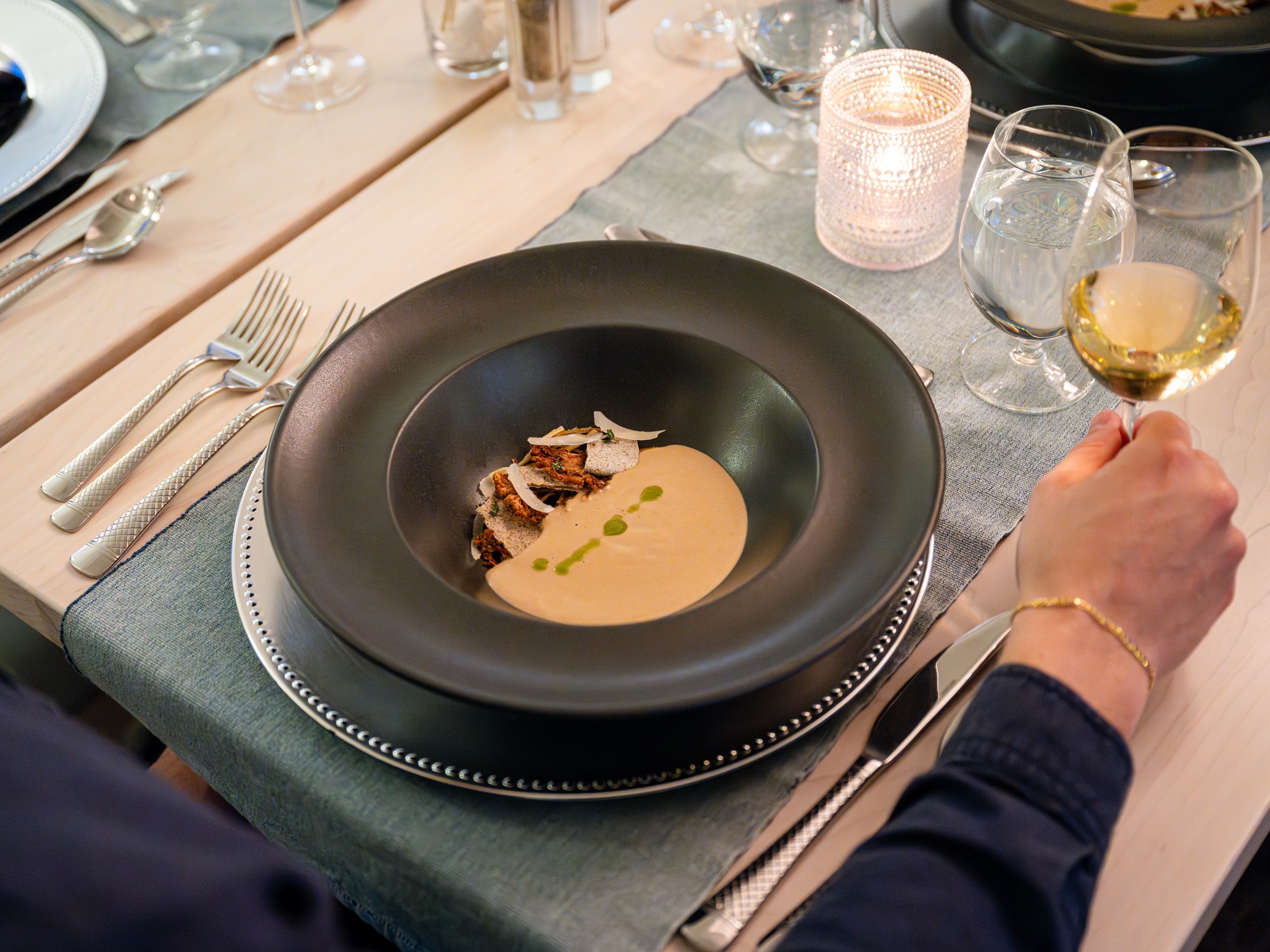 An over the shoulder view of a black bowl with gourmet soup at Tattingstone Inn in Wolfville, Nova Scotia