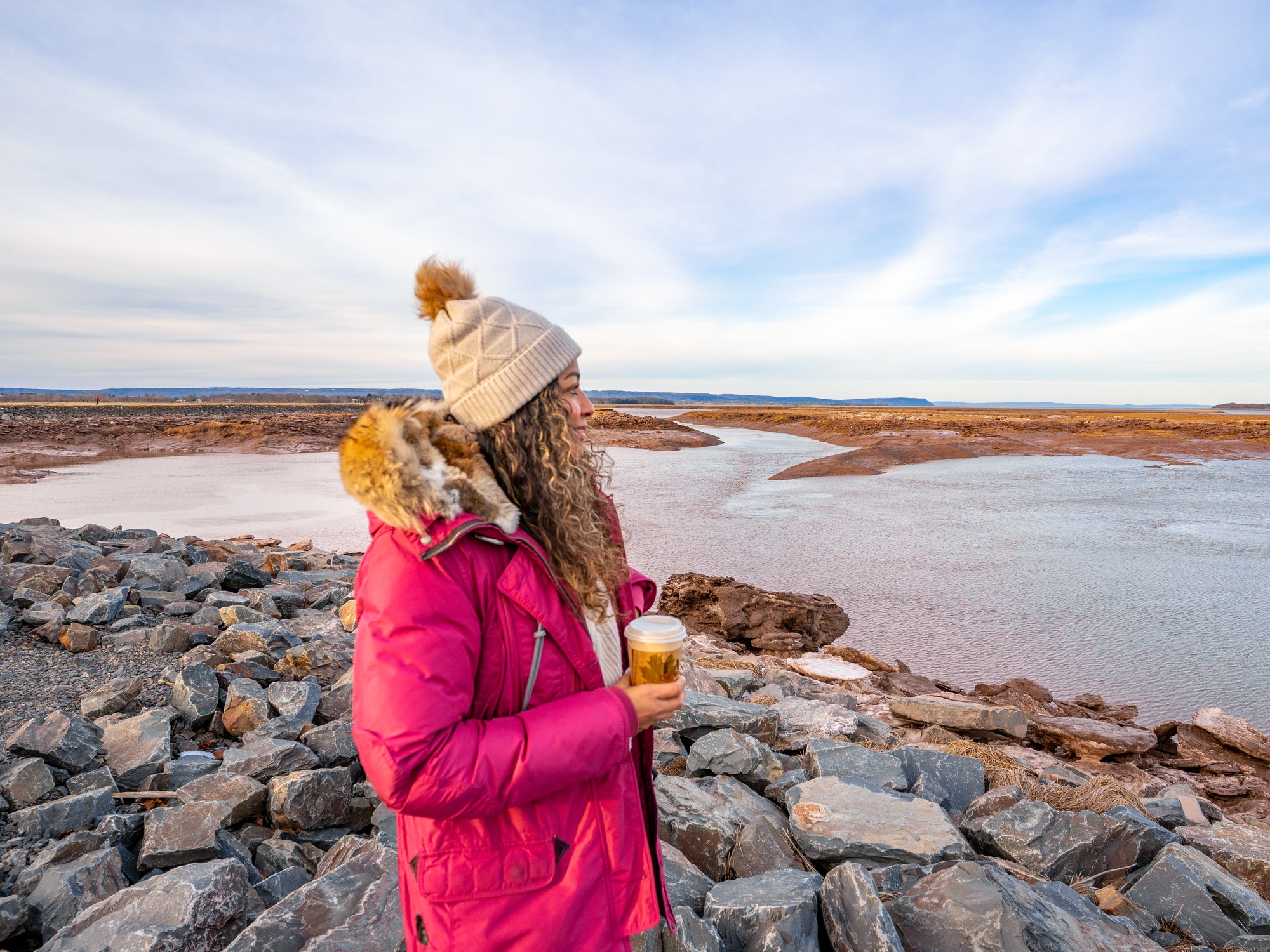 A woman looks out at the waterfront in Wolfville during winter.