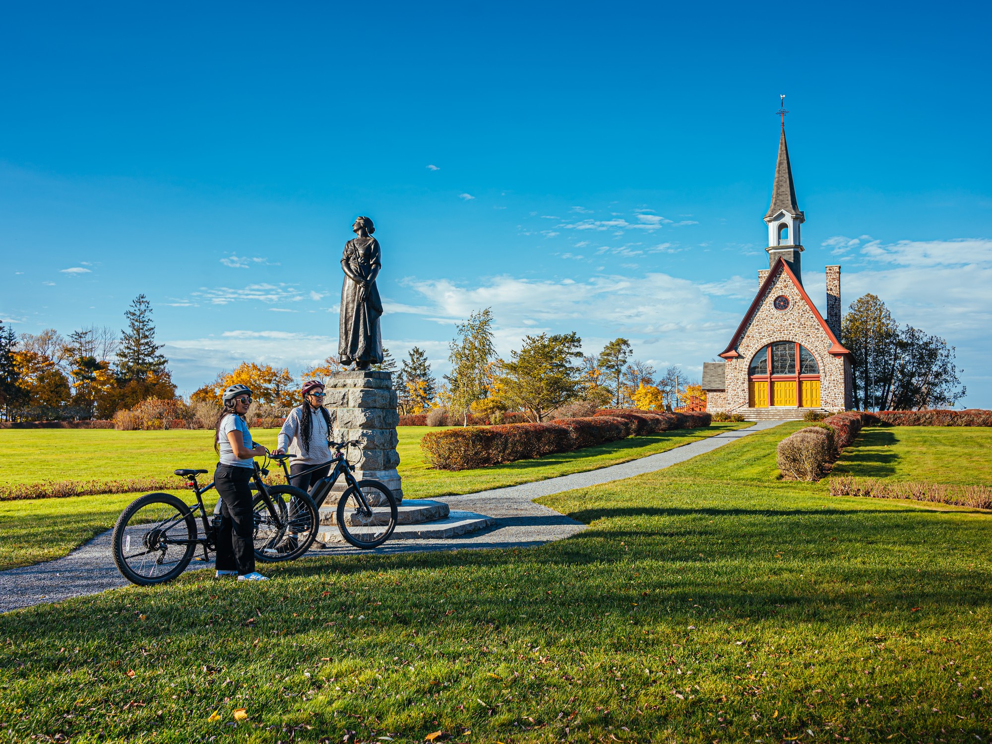 Two cyclists at the church at Grand Pre National Historic Site in Nova Scotia
