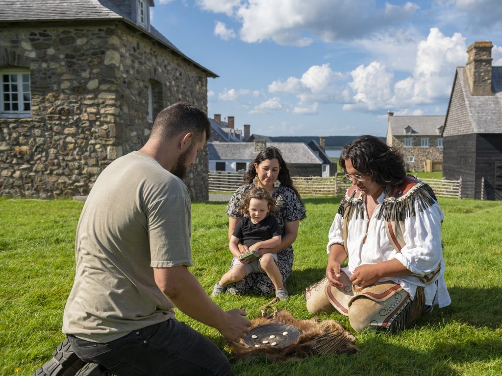 A family plays the Mi'kmaw game Waltes at Fortress of Louisbourg in Nova Scotia